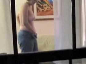Naked mature woman voyeured masturbating through window