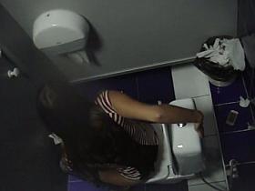 A brunette peeing in the common bathroom