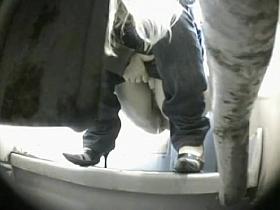 A blonde wearing high heels is pissing very candidly