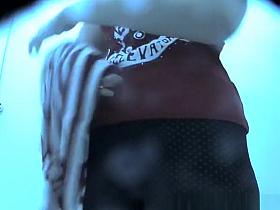 Woman in colorful dark bikini changes it