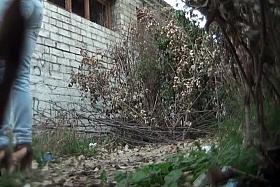 Ladies use the side of an abandoned building as a toilet