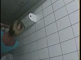 A blonde is pissing in the college toilet