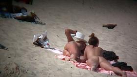 Nude sun tanning girls expose themselves to a beach spy cam