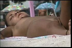 Raunchy floozy lying on a nude beach