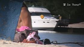 Babe with small tits and shaved vagina relaxes on the beach