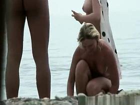 Nudist putting sun protection on body