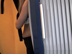 Blonde chick with small boobs undresses in tanning room