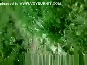 Woman sunbathing topless in grass