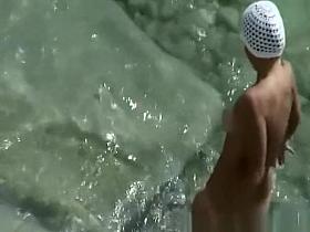 Nudist woman with small tattoo and trimmed pussy