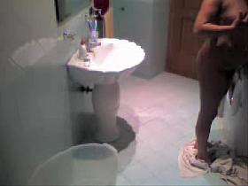 Hidden camera voyeur video with brunette in the bathroom