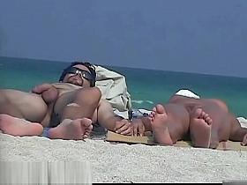 A nude girl is being watched by a beach spy camera