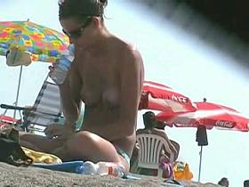 Sleek brunette checking out her big boobs in front the voyeur lens