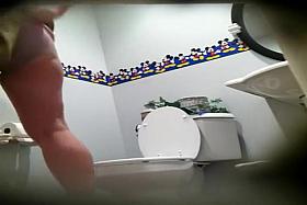 Two darling women piss in a public toilet