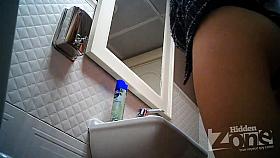 Two young babes with round ass in a toilet.