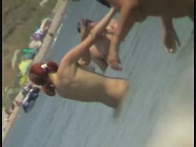 Beach spy cam catches a readhead girl running into the water