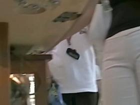 Blonde talking on the phone in the streets in tight white trousers