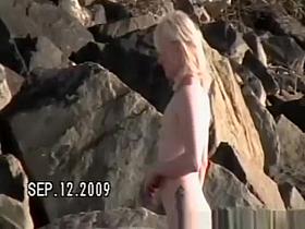 Small tits nudist at rocky beach