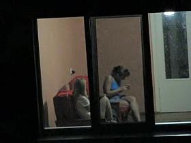 Brunette and blonde girls voyeured through hostel window