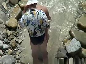 Naked woman in rocky beach