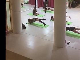 Scarcely-clothed stripteasers stretch before dancing on poles