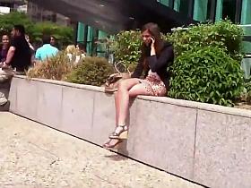 Leggy girl sitting on a wall