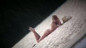 Hot body babe lying down on the beach surprised by a spy cam
