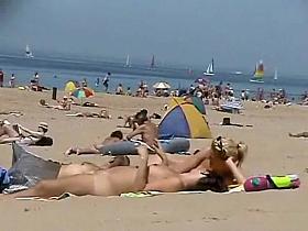 Sunny day at the public beach with two nudist girls