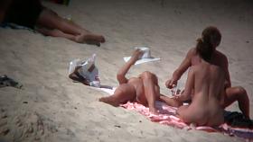 Mature blonde spreading her shaved pussy on the beach