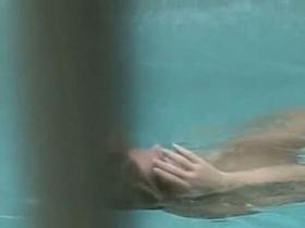 Gorgeous blonde with juicy tits swims completely naked in the pool by the beach