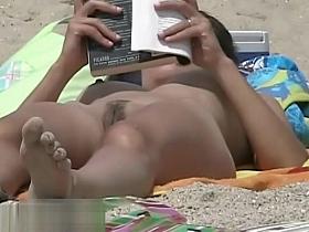 Hot body babe lying down on the beach surprised by a spy cam