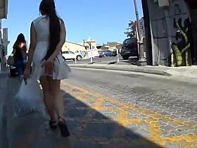 Cute girl protects her skirt from wind