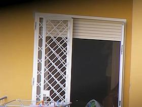 Real neighbor taking off her brassier at the open window