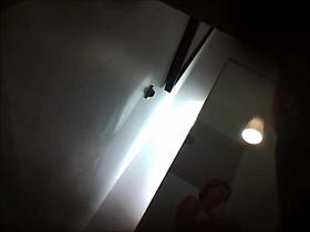 A girl is changing her top in the dressing room equipped with a hidden voyeur camera