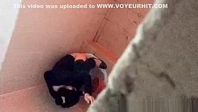 Asian woman spied over the toilet wall taking a pee