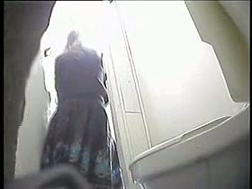 A juicy brunette caught by a spy camera pissing in a public toilet