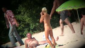 Voyeur on the beach capturing a tanned and naked girl