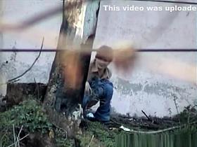 Girl pees next to big wall