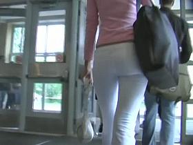Fit brunette in white skintight pants walks in a student hall candid porn