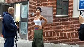 Crazy madam with a massive behind stands on the middle of the sidewalk