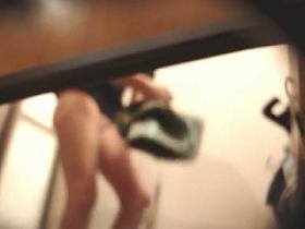 A bodibuilder woman is not aware that a hidden dressing room camera is spying after her