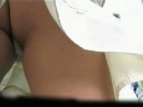 Tanned babe in a white, short skirt gives amazing upskirt