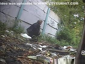 Mature woman peeing outdoors
