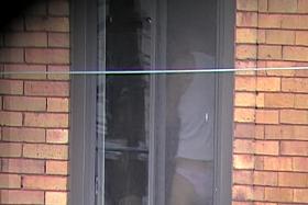 Sweet girl in white panty is looking out of the window