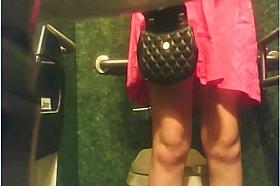 The luxurious gal in the pink dress is pissing in the toilet