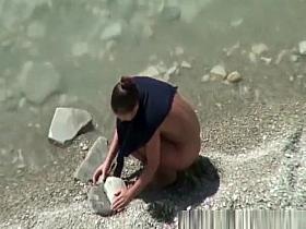 Nudist woman spied in rocky beach