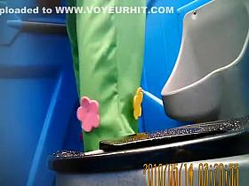 Woman in green pants pissing