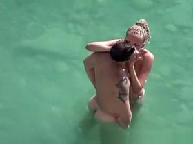 Nude woman and her man refreshing in the water