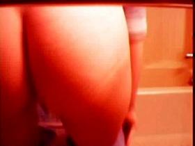 A girl is taking off her jeans and peeing in the toilet