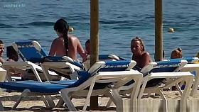 Pretty topless girls sunbathing on the beach