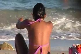 a brunette on the beach with a giant and divine ass